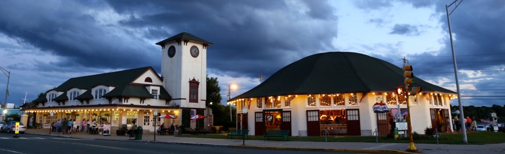 The carousel building, clock tower and adjacent building lit up at night.